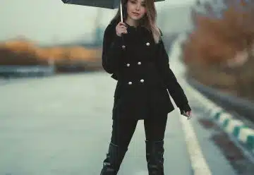 Woman Standing On A Road Holding An Umbrella
