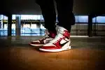 person wearing white-red-and-black Nike X Off-White Air Jordan 1's