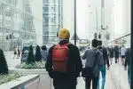 un homme avec un sac à dos marchant dans la rue